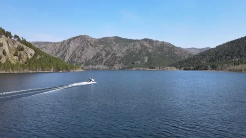 Drone flight behind a boat the river and mountains and forest on a sunny day Video stock 199041084