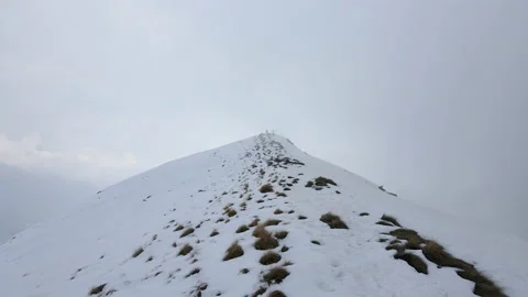 Drone flight into the clouds in natural snowy mountains landscape over the ridge Stock Footage 150871709