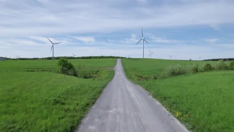 Drone Flight down a Dirt Road towards a wind mill Stockbeeldmateriaal 197569073