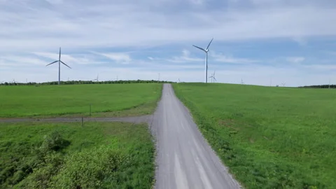 Drone Flight down a Dirt Road towards a wind mill Stockbeeldmateriaal 197569101