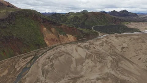 Drone flight forward over a braided river and rugged peaks Stock Footage 324966172