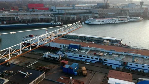 Drone flight forward past a crane boom over the industrial port of Nijmegen in Stock Footage 163033257