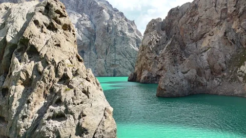 Drone flight inside Kel-Suu canyon over turquoise lake in Kyrgyzstan. Stock-Footage 321131628
