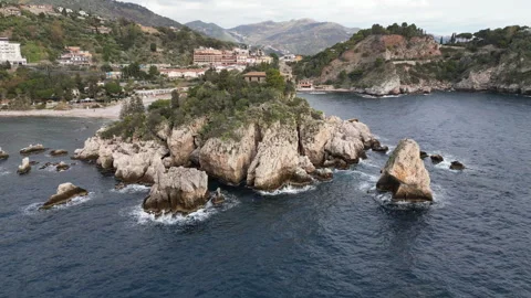 Drone flight Isola Bella, peninsula w rocky cliffs and beaches, Taormina Italy Stock Footage 345043906