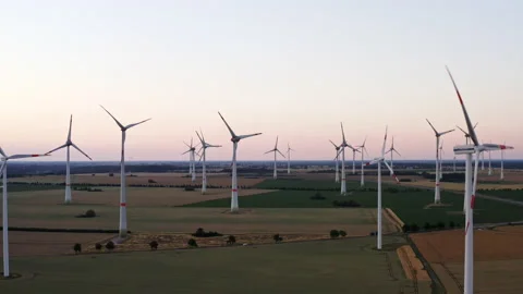 Drone flight to the left over a large field with many wind turbines spinning. 스톡 동영상 163100662