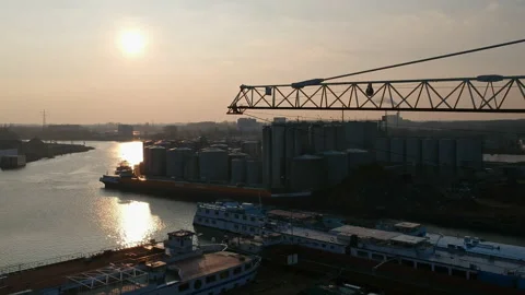 Drone flight leftwards past a crane boom over the industrial port of Nijmegen in Stock Footage 163033615