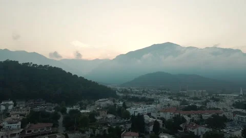 Drone flight, mountains in the clouds, city by the sea at sunset 4k Stock Footage 214927490