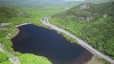 Drone flight next to Echo Lake in New Hampshire, surrounded by nature on a Stock Footage 342593563