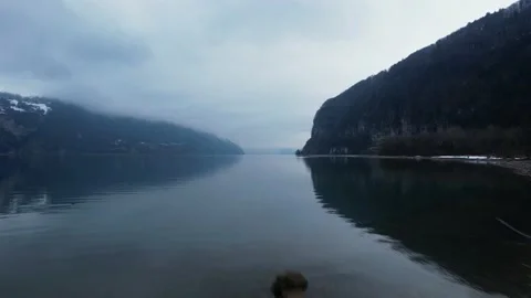 Drone flight next to a man with bright yellow jacket on a beach in the winter. Video stock 167306411