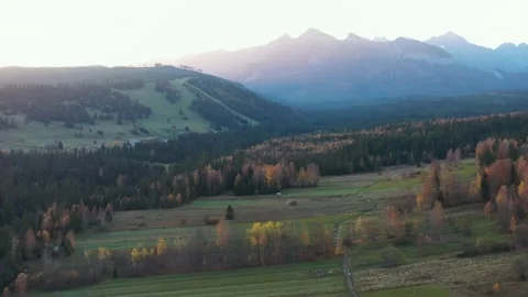 Drone flight over autumn valley with mountains at sunset Video stock 333833972