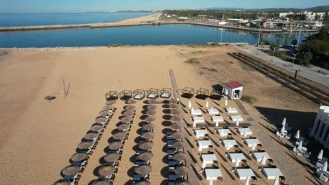 Drone flight over beach loungers and umbrella in Vilamoura Beach, Algarve Stock Footage 239460118