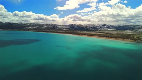 Drone flight over Bear Lake Utah with turquoise water and mountain shoreline Stock Footage 335080853