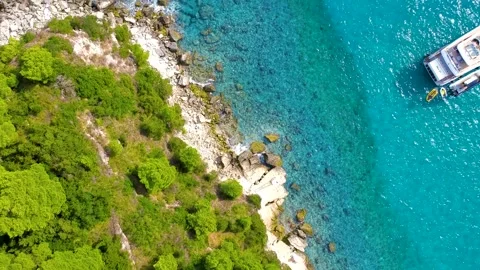 Drone flight over beautiful pebble beaches, forests, and calm tropical sea Stock Footage 234344416
