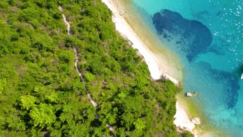 Drone flight over beautiful pebble beaches, forests, and calm tropical sea Stock Footage 234344430