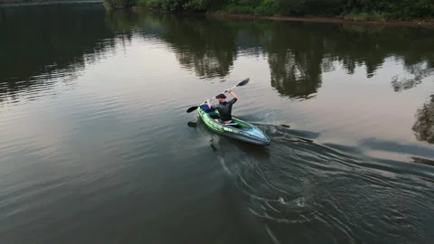 Drone flight over beautiful river. Young bearded male tourist kayaking boat Stock Footage 164746238
