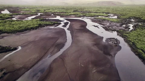 Drone flight over braided river in green lava field landscape Stock Footage 166500964