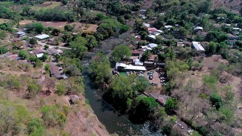 Drone flight over  buildings next to a river in Central America Stock Footage 101308489