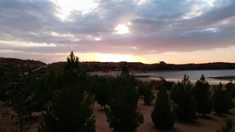 Drone flight over a calm lake during sunset Stock Footage 220759879