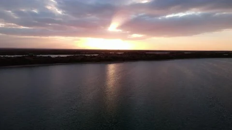 Drone flight over a calm lake during sunset Stock Footage 230828180