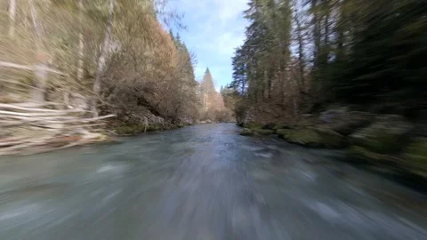 Drone flight over clear water river in Switzerland with trees in the background Stock Footage