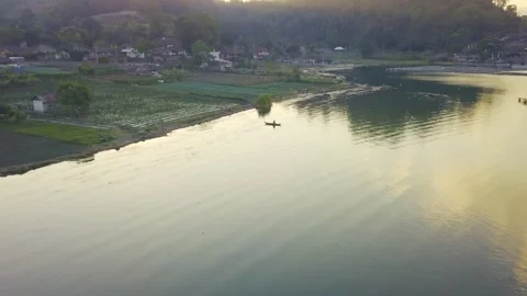 Drone flight over countryside area vegetable farm near lake with farmers resting Stock Footage 131192192