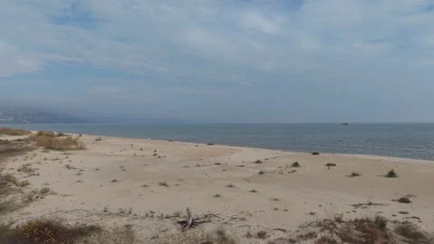 Drone flight over deserted sandy beach and calm blue sea Stock Footage 321046846