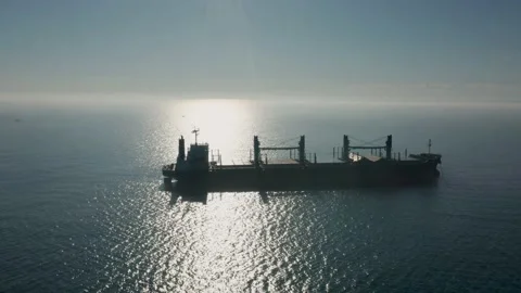 A drone flight over an empty container ship into the sea in the morning fog Stock Footage 132643079