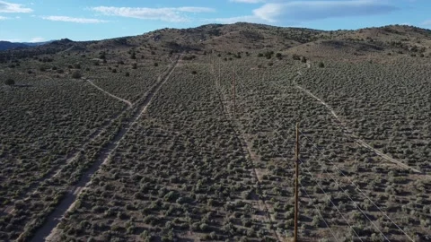Drone flight over empty desert hills with power lines and dirt roads. Stock Footage 200289787