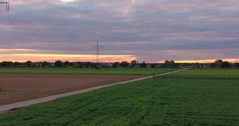 Drone flight over field and power line at red sunset Stock Footage 320308260