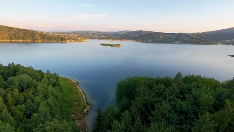 Drone flight over forest revealing Mucharskie Lake at sunset Stock Footage 314310237