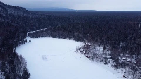 Drone flight over frozen river near mountain with winter forest in winter Stock Footage 159540593