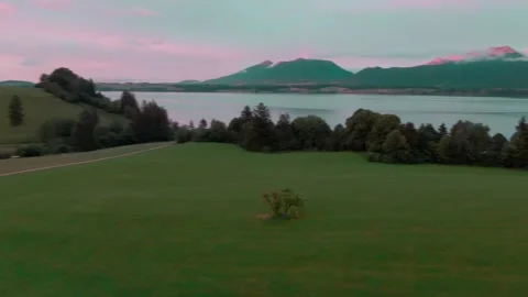 Drone Flight over Green Alpine Meadows and Mountain Lake at Sunrise, Wide Shot Video stock 341447930