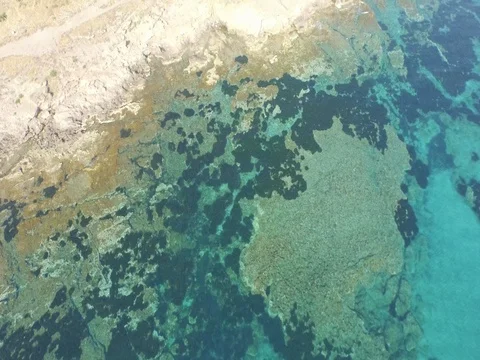 Drone Flight over the green blue sea with rocks toward the land Stock Footage 72553257