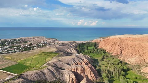 Drone flight over green valleys and red mountains near Issyk-Kul, Kyrgyzstan. Stock Footage 315433574