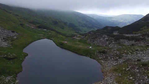 Drone flight over high mountain lake surrounded by green slopes Stock Footage 339660289