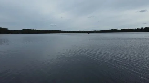 Drone flight over a lake and through the gap between two rocks in Sweden. Stock Footage 248098658