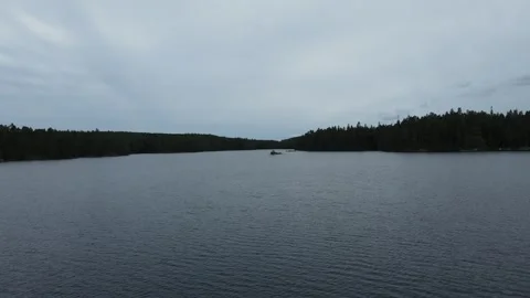 Drone flight over a lake approaching a forest in Sweden. Stock Footage 248099144