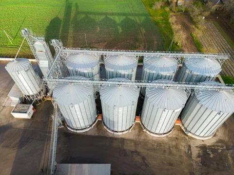 Drone flight over a large agro-industrial complex and barrels of grain. silos Stock Photos