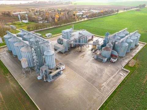 Drone flight over a large agro-industrial complex and barrels of grain. silos Stock Photos