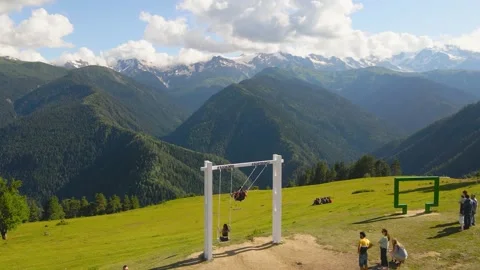 Drone flight over large swing against background of mountains in Georgia Stock Footage 214331661