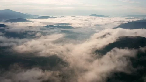 Drone flight over low clouds and morning mists covered mountain slopes Stock Footage 146173642