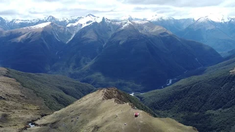 Drone Flight Over Mount Aspiring National Park with Red Hut on Mountain Peak 4K Stock Footage 312339923