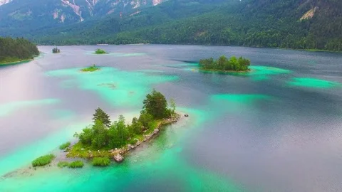 Drone flight over mountain lake Eibsee beneath Zugspitze peak. Stock Footage 72002904