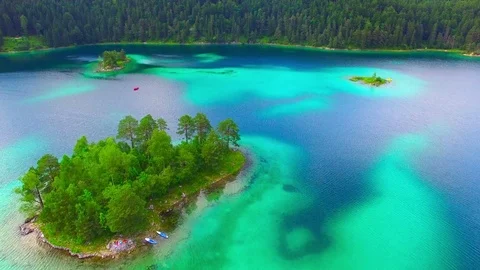 Drone flight over mountain lake Eibsee beneath Zugspitze peak. Video stock 84835484