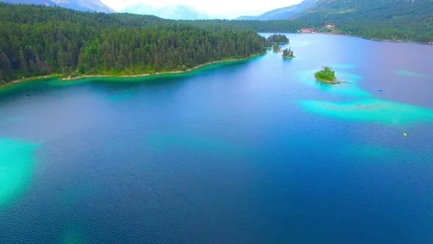 Drone flight over mountain lake Eibsee beneath Zugspitze peak. Video stock 84835591
