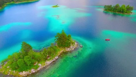 Drone flight over mountain lake Eibsee beneath Zugspitze peak. Video stock 84836388
