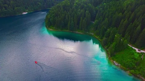Drone flight over mountain lake Eibsee beneath Zugspitze peak. Video stock 84836503