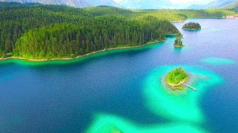 Drone flight over mountain lake Eibsee beneath Zugspitze peak. Video stock 84837014