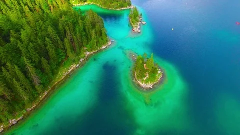 Drone flight over mountain lake Eibsee beneath Zugspitze peak. Video stock 84837412