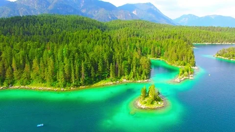 Drone flight over mountain lake Eibsee beneath Zugspitze peak. Video stock 84837549